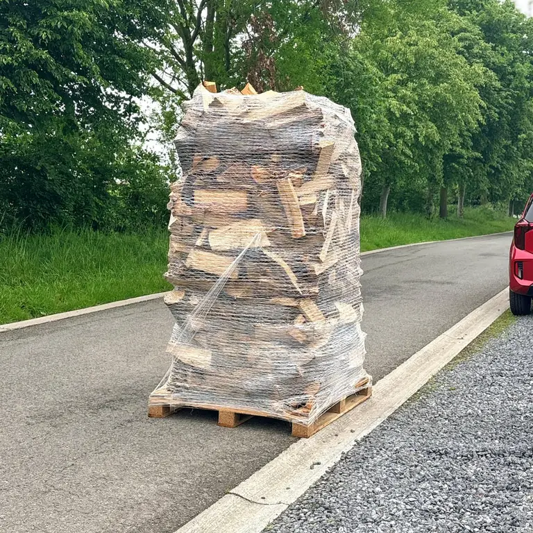 Palette de bûches de bois sec filmée, prête à être déposée
