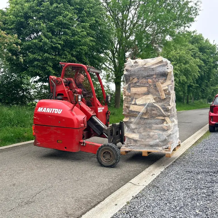 Transpalette Manitou transportant une palette de bûches jusqu'au domicile du client